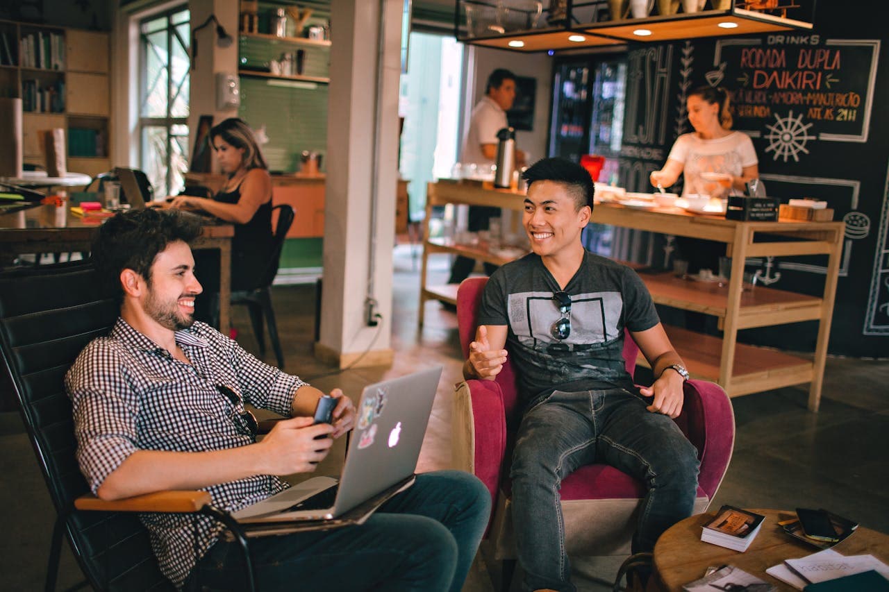 Two men chatting and smiling in a casual workspace